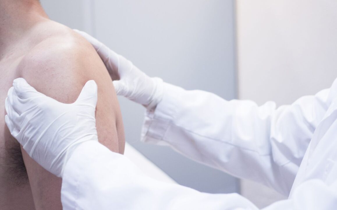 lékař vyšetří rameno s artrózou